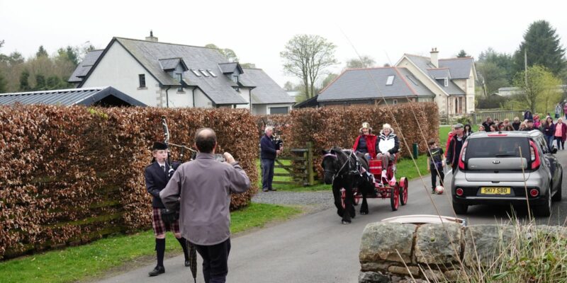 Pipers and horse and cart lead the way to the Coronation celebrations at Penney's Wood on the Back Crook.